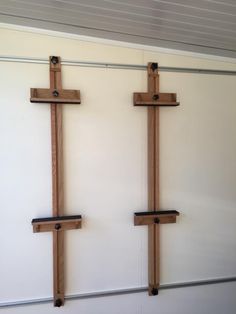 two wooden crosses mounted to the side of a white wall next to eachother