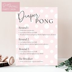 a pink and white polka dot party pong sign next to some decorations on a table