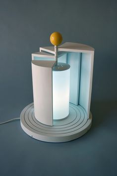 a lamp that is sitting on top of a round stand with a ball in it