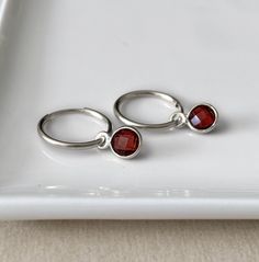 Garnet hoop earrings - sterling silver endless hoops - faceted tiny gemstone charm - convertible earring - simple dainty hoop earrings Simple sterling silver hoops with a removable gemstone charm. 2 styles for the price of one.  More gemstones available here: https://www.etsy.com/ca/listing/970326370/gemstone-hoop-earrings-sterling-silver If you want to purchase an extra pair of gemstones, please contact me. * SIZE: 15mm hoops with a 6mm stone  * MATERIAL: Sterling silver, faceted gemstone, also Sterling Silver Huggie Earrings With Birthstone, Stackable Sterling Silver Huggie Earrings As Gift, Sterling Silver Stackable Huggie Earrings As Gift, Dainty Sterling Silver Huggie Earrings With Birthstone, Dainty Sterling Silver Birthstone Huggie Earrings, Sterling Silver Huggie Stackable Earrings, Gift Sterling Silver Stackable Hoop Earrings, Sterling Silver Stackable Earrings As Gift, Stackable Sterling Silver Earrings As Gift