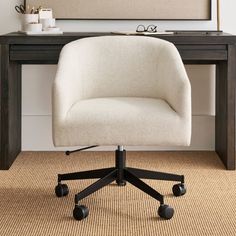 an office chair sits in front of a desk with a framed painting on the wall