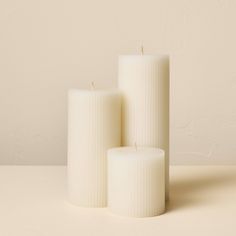 three white candles sitting next to each other