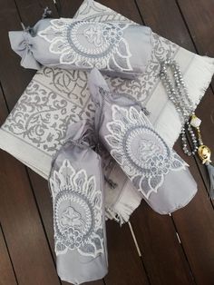 three napkins with tassels on them sitting on a wooden floor next to beads