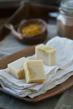 three pieces of soap sitting on top of a wooden plate