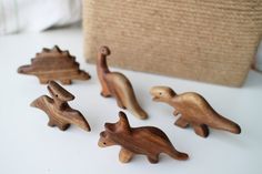 small wooden toy dinosaurs sitting on a table