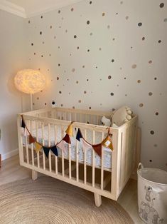 a baby's room with polka dot wallpaper and crib