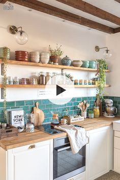 a kitchen filled with lots of counter top space and open shelving above the stove