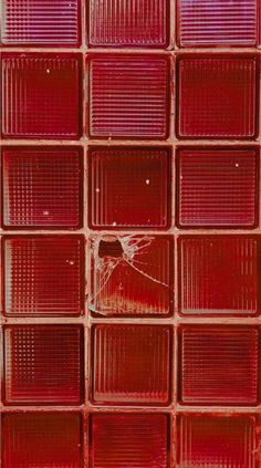 a red glass block wall with a broken window