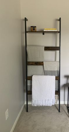 a shelf with towels and other items on it next to a chair in a room