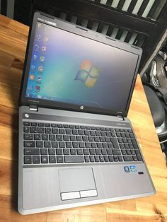 an open laptop computer sitting on top of a wooden table