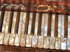 an old wooden piano with white and brown keys