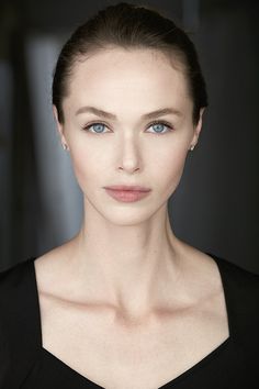 a woman with blue eyes is posing for the camera