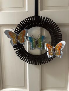 a wreath with two butterflies hanging on the front door