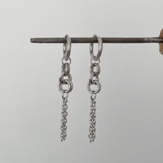 Add an edgy touch to your everyday look with these stunning chain earrings in stainless steel. These versatile earrings are perfect for adding a minimalist yet modern flair to any outfit. Handcrafted with high-quality stainless steel, they are durable, hypoallergenic, and will last for years to come. Whether you're heading to work or a night out with friends, these chain earrings are sure to make a statement. Treat yourself or a loved one to these chic and trendy earrings that are sure to become Trendy Sterling Silver Piercings For Everyday, Trendy Everyday Sterling Silver Piercings, Trendy Sterling Silver Drop Cartilage Earrings, Modern Drop Earrings With Silver Chain, Sterling Silver Chain Drop Earrings, Modern Silver Chain Drop Earrings, Modern Silver Chain Earrings, Elegant Hypoallergenic Metal Piercings, Trendy Metal Dangle Hoop Earrings