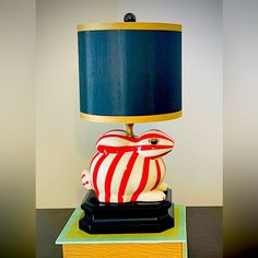 a lamp that is sitting on top of a wooden block with a blue shade over it