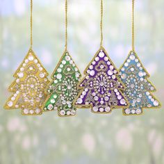 three christmas ornaments hanging from chains on a green and white background with snowflakes