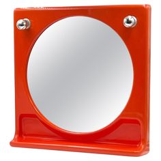 an orange square shaped mirror on a white background