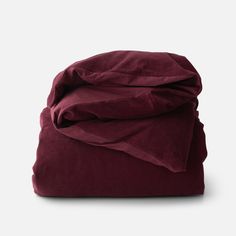 the burgundy blanket is folded up and ready to be used as a bedding material