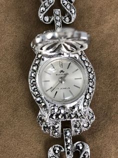 Vintage Stunning 1950's Bucherer Ladies Wrist Swiss Peak-A-Boo Watch from .800 Swiss Euro Silver and Marcasite Settings with Safety Chain This beautiful ladies wristwatch is in Excellent vintage condition. All the stones are intact, it winds and runs. It's extra nice 6.25 inches in length 3/4 inch diameter Silver Case Rare in this running condition shipping included The mineral marcasite, sometimes called white iron pyrite, is iron sulfide with orthorhombic crystal structure. It is physically an Vintage Diamond Watch With Diamond Hour Markers For Evening, Timeless Collectible Jewelry With Round Dial, Antique Diamond Watch For Evening, Hallmarked Vintage Jewelry For Evening, Vintage Hallmarked Jewelry For Evening, Silver Art Deco Diamond Watch For Evening, Silver Art Deco Diamond Evening Watch, Vintage Jewelry And Watches With Diamond Hour Markers, Antique Silver Diamond Watch