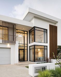 a modern house with white walls and black trim on the windows, front door and stairs