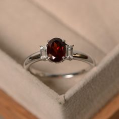 This ring features a 6*8mm ova cut garnet and sterling silver finished with rhodium. Customization is available. It is made by hand, and it will take about 7 days to finish the ring after your payment is completed. Any question, just let me know. :) My shop homepage: https://www.etsy.com/shop/LuoJewelry?ref=l2-shopheader-name Ruby Rings Silver, Engagement Ring With Red Stone, Red And Silver Engagement Ring, Silver Garnet Engagement Ring, Red Engagement Ring Silver, Silver Ring Gemstone, Garnet Silver Ring, Ruby Wedding Rings Silver, Garnet Wedding Rings Silver