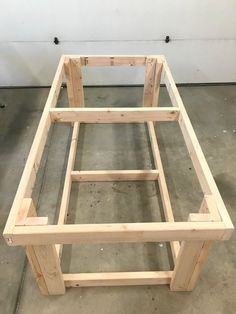 a wooden bed frame sitting on top of a cement floor