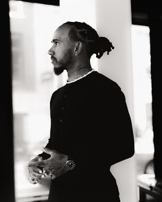 a black and white photo of a man with dreadlocks looking off into the distance