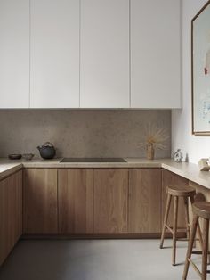 a kitchen with white cabinets and wooden stools