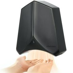 a person holding their hand up to a black object on top of a white surface