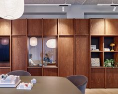 an empty meeting room with wooden walls and shelves