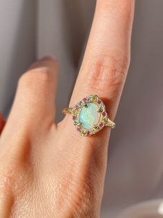 One of a kind 14k Yellow Gold Australian Opal Ring, enraptured by a dreamy pastel halo of Aquamarine, Pink Sapphires and Yellow Sapphires. 💌 Please write desired size (between 4-8) in *Notes* section at checkout Opal enhances cosmic consciousness and imparts mystical visions. Acting as a mirror, it reflects your thoughts and feelings back to you while shielding you as a karmic protector to deflect empathic emotions that are shone onto you by others. Opal is a teacher - amplifying our emotions s Fine Jewelry Opal Ring With Halo In 14k Gold, Heirloom 14k Gold Opal Ring With Halo, Elegant Multicolor Opal Ring, Ethereal Yellow Gold Gemstone Rings, Luxury 14k Gold Opal Halo Ring, Ethereal Yellow Gold Wedding Rings, Fine Jewelry Opal Ring With Halo, Multicolor Halo Rings Fine Jewelry, Multicolor Oval Jewelry With Halo Setting