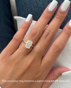 a woman's hand with white manicured nails and a diamond ring