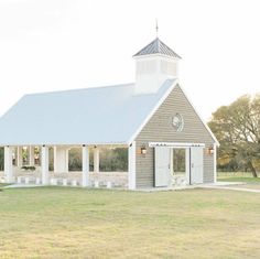 a small white church in the middle of a field