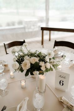 the table is set with white flowers and candles