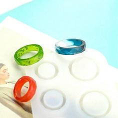 three different colored rings sitting on top of a white table next to a blue pool