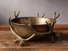 a metal bowl with antlers on it