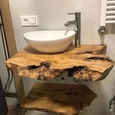 a bathroom sink made out of wood with a white bowl on the top and metal faucet