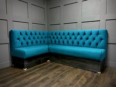 a blue couch sitting on top of a hard wood floor next to a wooden wall