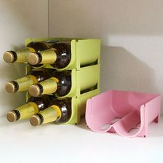 there is a wine rack with bottles in it and a pink bin next to it