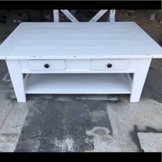 a white coffee table with two drawers on it