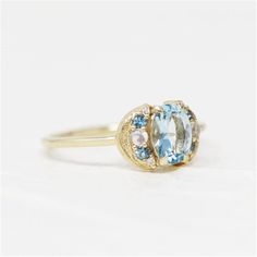 Discover the unique charm of the LeConte Impasto Collection with this handcrafted 14K yellow gold artisan fashion ring, size 6. Designed for those who appreciate the beauty of art and nature, this exquisite piece features a central 0.97ct oval aquamarine, enveloped by an array of stunning gemstones.Key Features:-Exceptional Craftsmanship: Each ring is a masterpiece from the LeConte Impasto Collection, reflecting the pinnacle of artisanal skill.-Captivating Centerpiece: A mesmerizing 0.97ct oval aquamarine takes center stage, symbolizing tranquility and eternal youth.-Elegant Accents: Complemented by 4=0.05tw round blue topazes and 2=0.01tw cabochon moonstones, adding layers of depth and intrigue.-Sparkling Diamonds: Embellished with 4=0.02tw round G/H SI1 diamonds, offering a subtle shimme Oval Aquamarine Ring, Artisan Fashion, Eternal Youth, Aquamarine Ring, Aquamarine Rings, Fashion Ring, Center Stage, Carolina Blue, G H