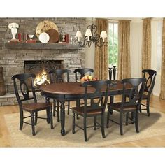 a dining room table with six chairs and a fireplace in the backgrounge