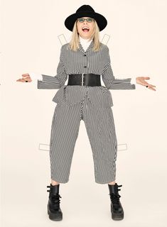 a woman in black and white striped jumpsuits with her hands out to the side