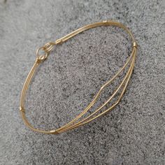 A delicate bracelet of three strands of lightweight 14kt gold filled wire pulled open in a dainty pointed design. So sweet and feminine, it would make an ideal gift for a young lady's confirmation, graduation, or birthday! The sturdy built-in hook and eye clasp is easy to get on and off by yourself. Choose the best size from the variations for a perfect fit! Add on a jewelry polishing cloth to keep your bracelet--and ALL your jewelry--shiny clean! https://www.etsy.com/listing/732310828/jewelry-p Adjustable 14k Gold Cuff Bracelet, Gold Wire Wrapped Bracelets In 14k Gold Filled, Gold Wire Wrapped 14k Gold-filled Bracelets, Gold Stackable Wrap Bracelet, Adjustable 14k Gold-filled Jubilee Bracelet, Wire Wrapped 14k Gold Filled Bracelets, Stackable Yellow Gold Brass Bracelets, Adjustable Stackable 14k Gold Bracelets, Dainty Hand Wrapped Gold Bracelet