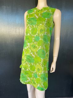 "1960s Kitty Copeland dress. Green floral on polyester chiffon, green acetate liner. Simple column shape. Two decorative bows on sides near hem. Nylon zip back. Measurements are  36\" bust 34\"waist 36\" hips 36\" length 14\" back shoulders (between armholes) Lovely dress shows well, some repairs noted by left bow as shown in pics." Green Knee-length Mod Dress, Green Mod Knee-length Dress, Green Silk Knee-length Dress, Green Knee-length Silk Dress, Mod Green A-line Dress, Green Mod A-line Dress, Green Silk Dress For Garden Party, Green Lined Dress For Garden Party, Green Lined Dresses For Garden Party