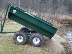 a green dump truck sitting on top of a grass covered field