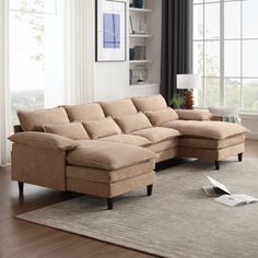 a living room with a large sectional couch and rug in front of the window,