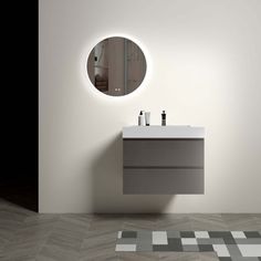 a bathroom with a sink, mirror and rug on the floor in front of it