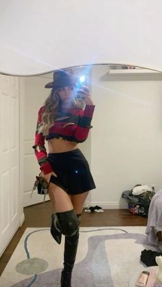 a woman wearing boots and a hat is taking a selfie in the mirror with her cell phone