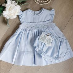 This Sweet And Elegant Little Dress By Feltman Brothers In A Girls Size 3 Months Is Adorable! Known For Their Quality Children's Clothing, This Piece Doesn't Disappoint!! The Waist Has A Lattice Design Smocking With Sweet Two-Toned Blue Rosebud Floral Vines With Green Embroidered Leaves.The Smocked Waist Has An Added Feature Which Is A Ruffled Edge-Super Cute! The Round Neckline Has 2 Layers Of Matching Piping Trim Held Together With Intricate Faggoting. The Ruffled-Flutter Sleeves Also Have Mat Cotton Smocked Dress With Ruffles For Baptism, Cute Smocked Dress With Flutter Sleeves, Cute Fitted Smocked Dress With Flutter Sleeves, Fitted Blue Smocked Dress For Playtime, Blue Smocked Dress With Flutter Sleeves And Ruffles, Light Blue Smocked Dress With Ruffles And Fitted Style, Cute Blue Smocked Dress With Ruffles, Blue Cotton Smocked Playtime Dress, Fitted Light Blue Smocked Cotton Dress